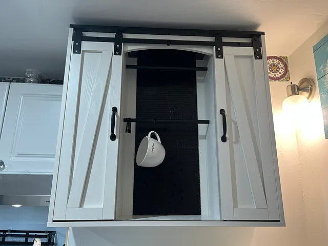 Really cute and functional storage cabinet with barn sliders and a bar for coffee mugs etc.