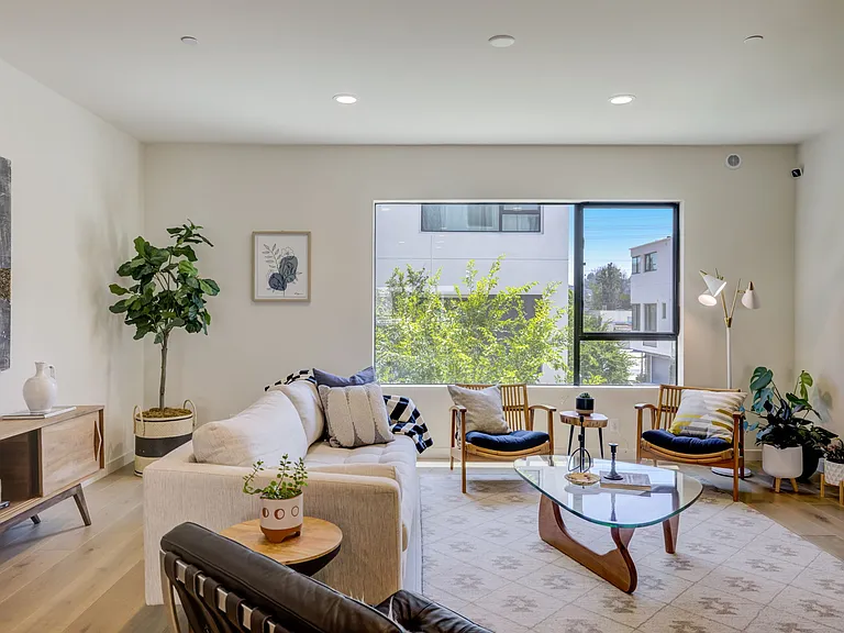 Living area featuring oversized windows that bring in abundant natural light and neighborhood views throughout the day.