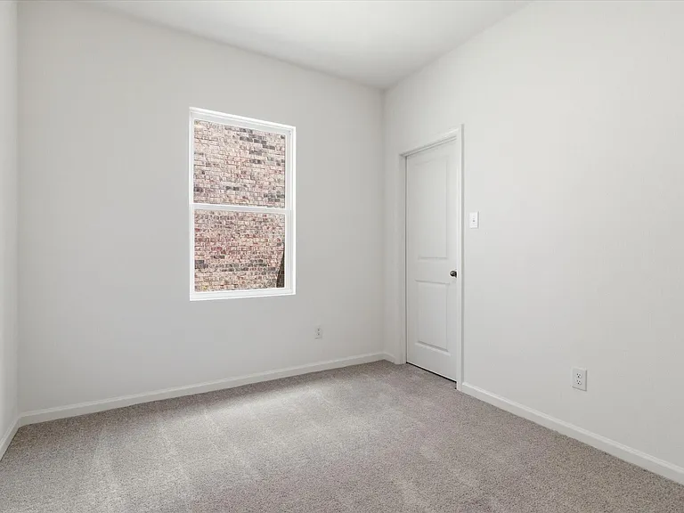 Bright room featuring neutral-toned walls, grey carpeting, and white trim
