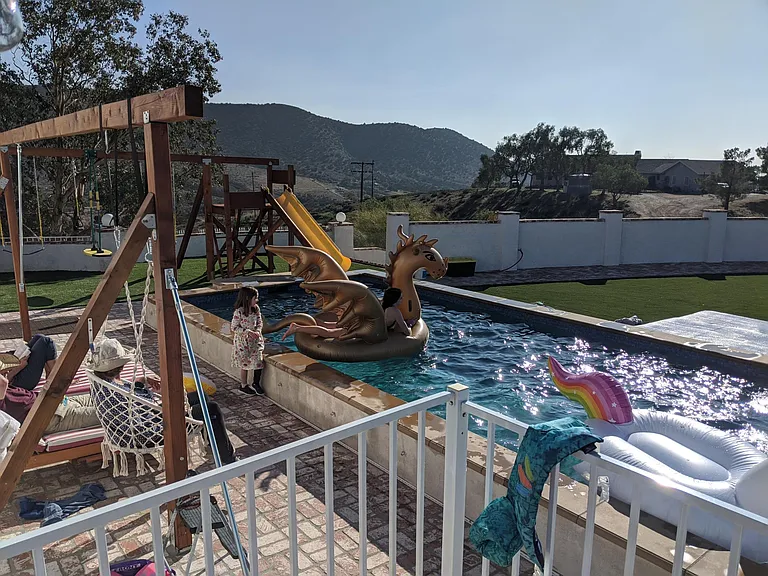 Current as-built showing trellis, swings, slide and raised edge heated pool. So much fun!