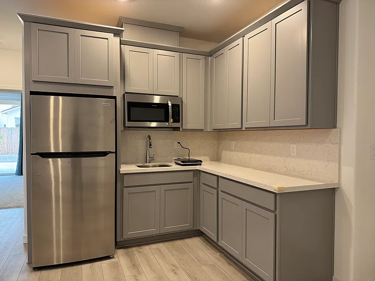 Refrigerator, vented microwave, single burner induction cooktop, sink, cabinets.