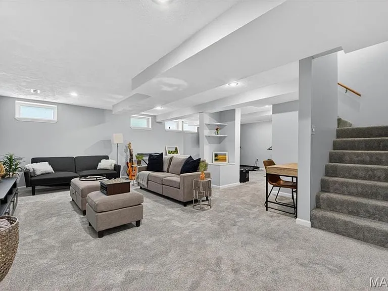 Expansive lower level living space featuring light gray carpeting, recessed lighting, and multiple egress windows