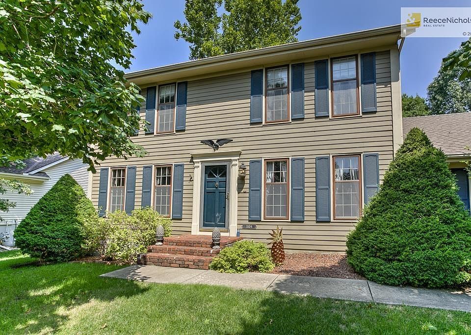 Traditional Colonial exterior boasts large trees