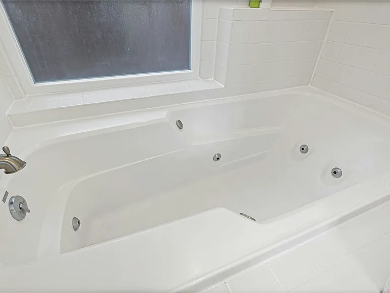 Soak in comfort unwind in your private jetted tub, perfectly positioned beneath a frosted window for peaceful light and added privacy.