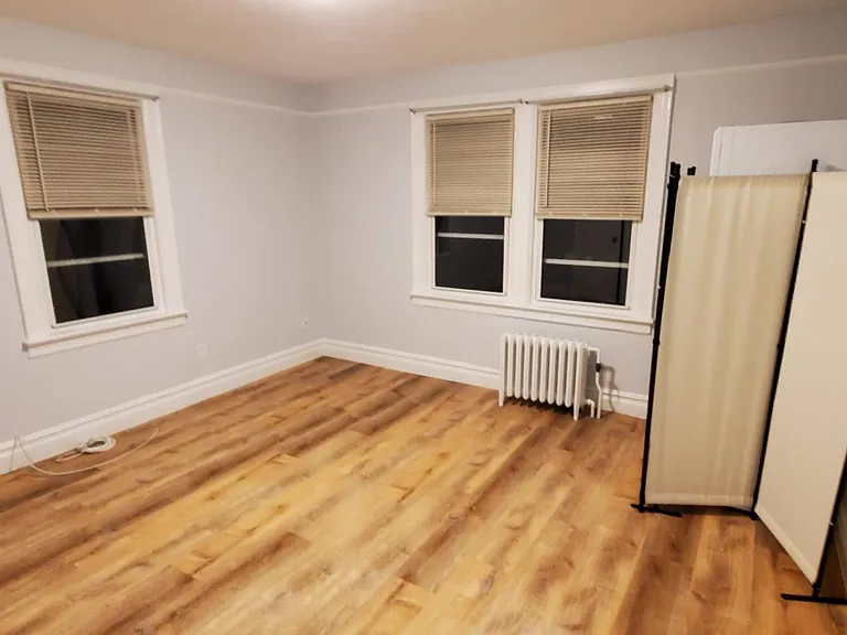 The bedroom seen from the entry door. Behind the screen is the washer dryer. You can use the screen or do something of your own. The double windows look out on the back yard