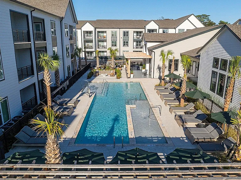 Luxury apartment pool courtyard with tanning ledges, lounge seating, cabanas, and resort-inspired outdoor amenities.
