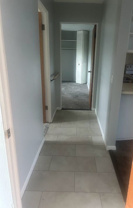 Viewpoint from bedroom door #1: bathroom door to the left down the hall, bedroom #2 at the end of the hall, entry to kitchen and living room to the right.