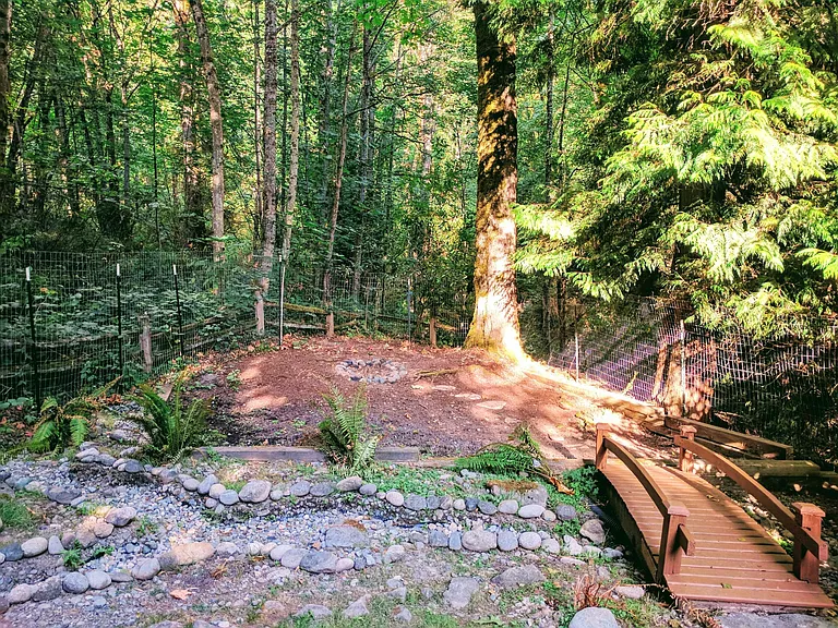 The stone pathway guides rain to meet the creek next to the house.