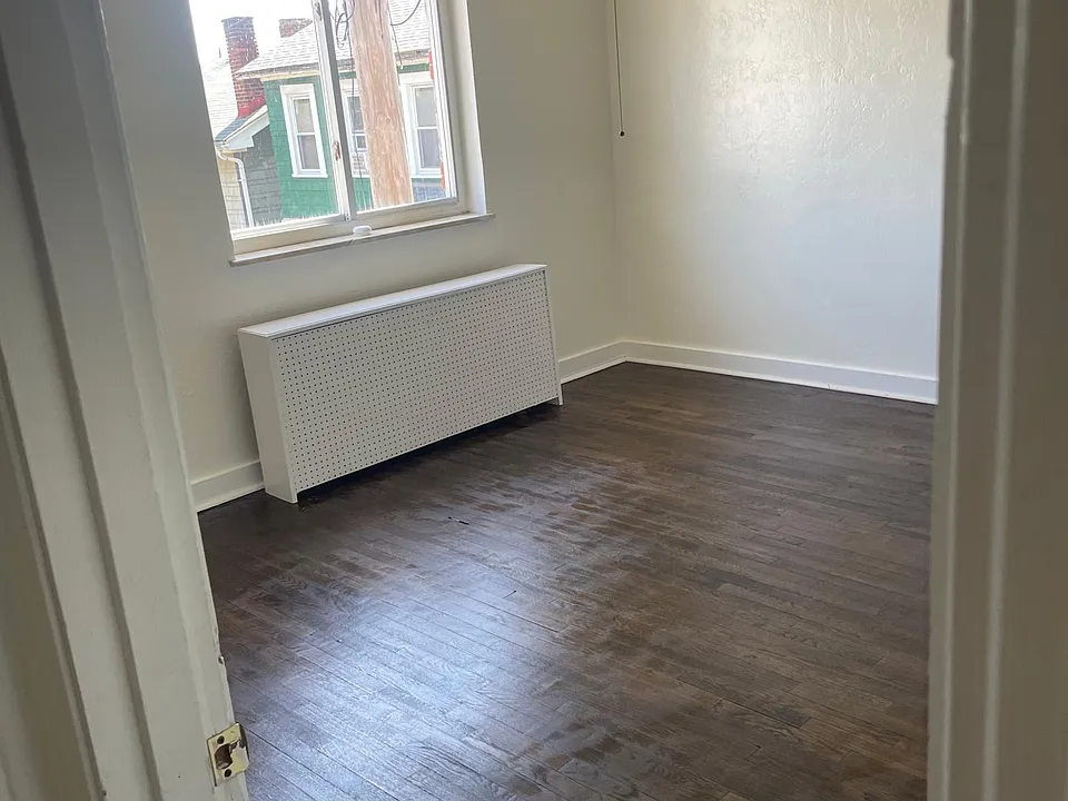 1st bedroom features window with blinds and a ceiling fan.