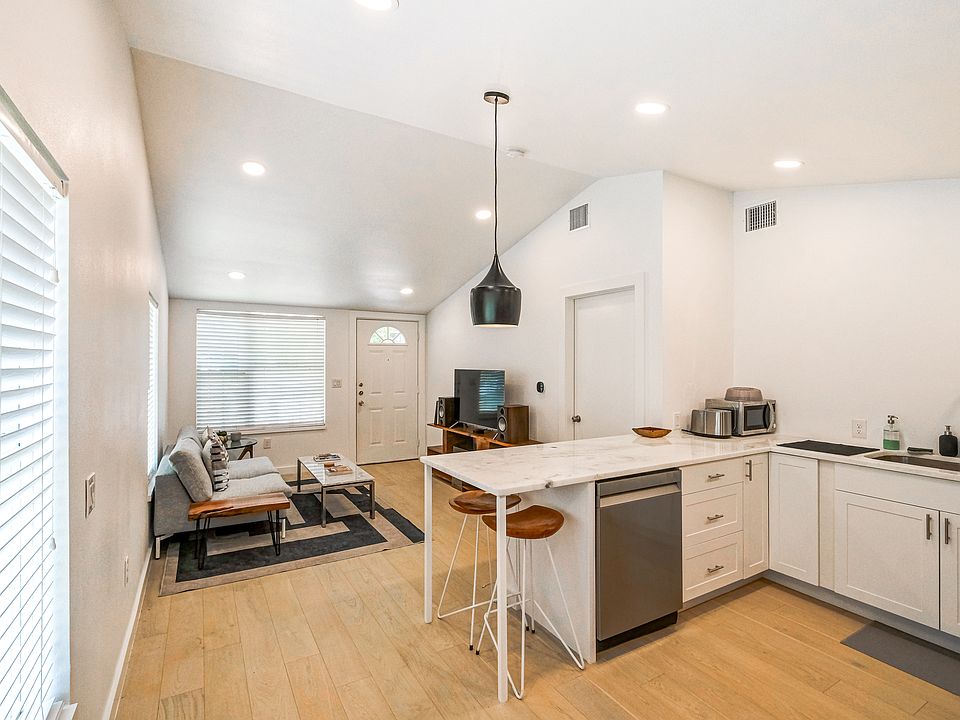 View from threshold into back half looking toward kitchen, living area, and front door entrance.