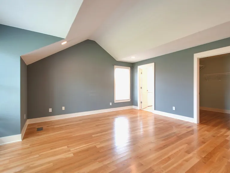 another view of the primary bedroom showing access to primary bath and to the large walk in closet