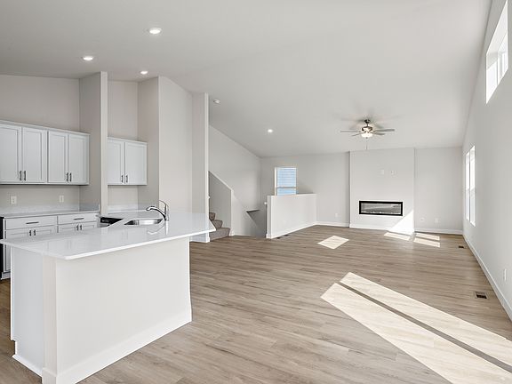 The family room is spacious with a ceiling fan and a fireplace