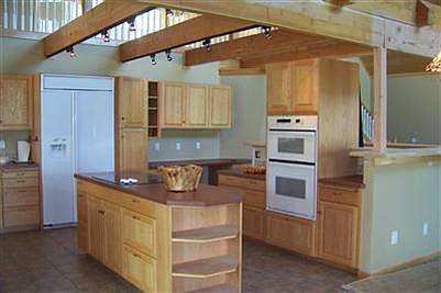 Open kitchen with bar to living room. Stove top located on island.