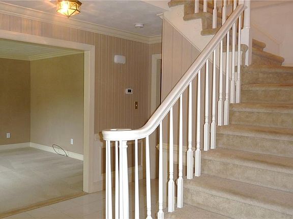 Stately foyer has a large coat closet and built-in lighted display cabinets on either side of entry door. 
