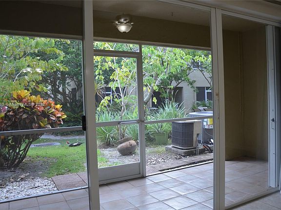 Screened patio with a garden view. Accordion hurricane shutters.
