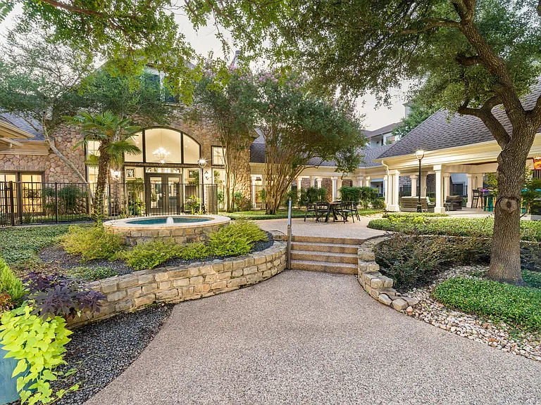 Enjoy peaceful moments or casual conversation in this inviting courtyard, framed by greenery and classic stone architecture.