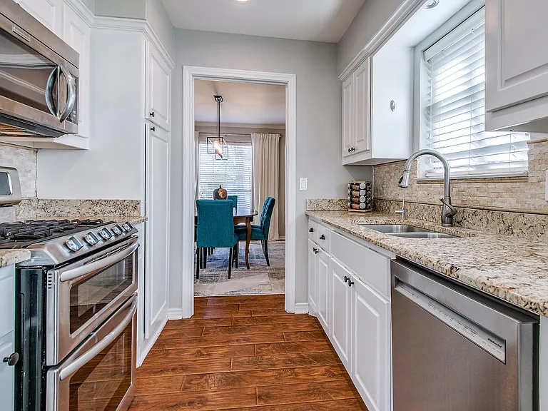 Bright Kitchen with Gas Stove, Granite Countertops, and Stainless Steel Appliances.