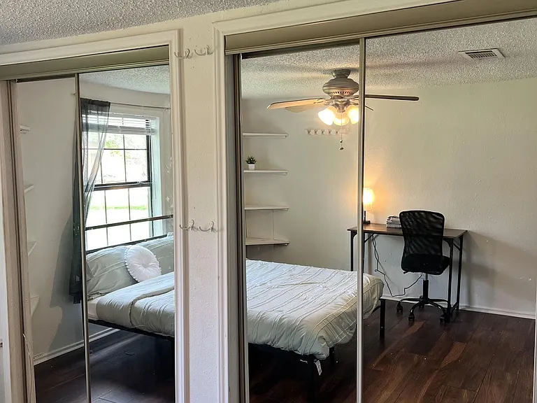 Bedroom includes mirrored sliding-door closet, ceiling fan with light, and a dedicated desk area near the window.