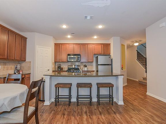 Modern SS Appliance Kitchen offers 42" cabinets and granite, photo highlights breakfast sitting area, large walk-in pantry, gas range, microwave, quiet dishwasher, and refrigerator is included. Extra built-in desk/entertainment center!