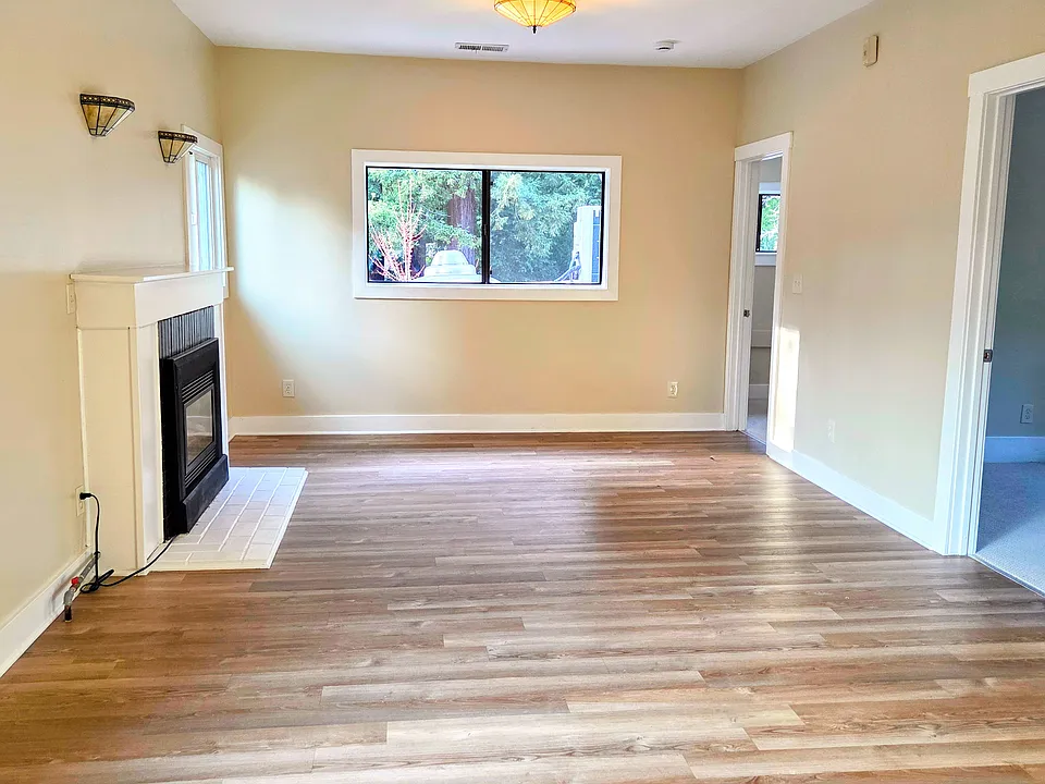 Main room. Doors to 3 bedrooms, bathroom hall, and kitchen. Luxury vinyl flooring and gas fireplace with blower.