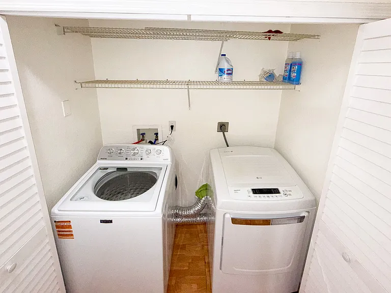 In-Unit Laundry Space with ample shelving / Espacio de lavanderia dentro de la unidad con amplias repisas
