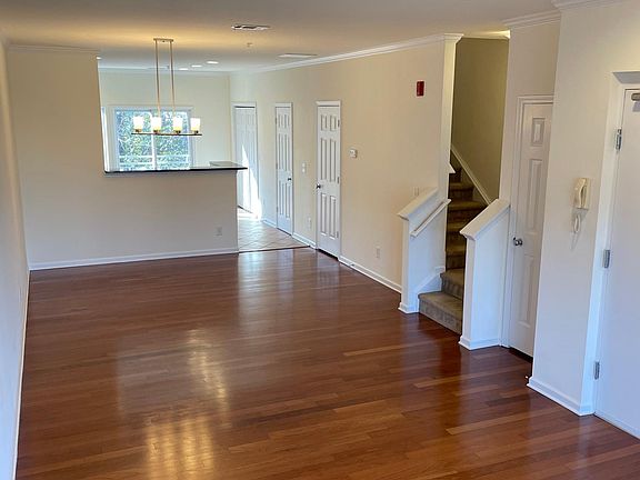 Hardwood flooring in living area with ceiling fan and gas fireplace.