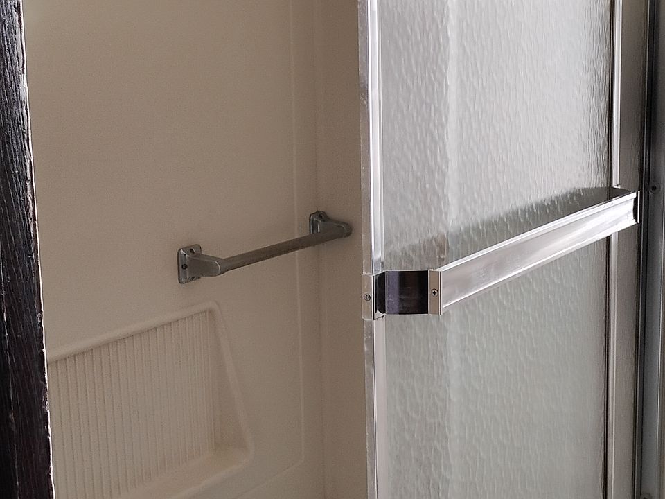 bathroom showing tub/shower combination with glass doors