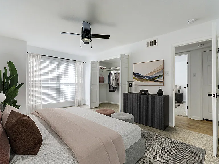 A bright bedroom is shown at ReNew on Cantrell with oversized closet and ceiling fan.