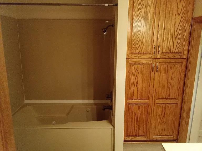 large storage area in bathroom. also bathtub has whirlpool tub.