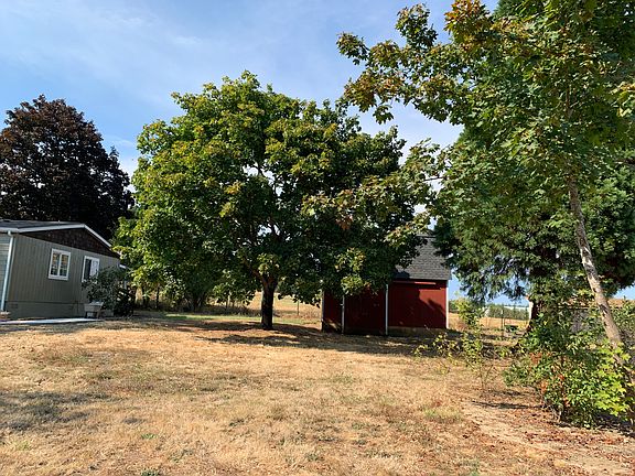 East side of home with small storage barn.