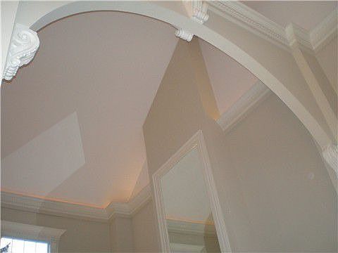 Fabulous arched entry into 2 story living room with ceiling lighting