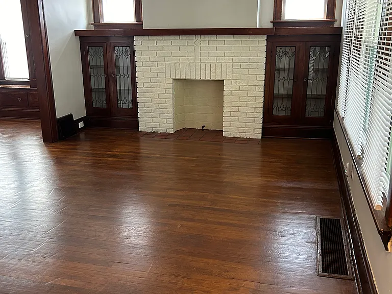 Living room with original leaded glass shelving units and refinished original wooden floors
