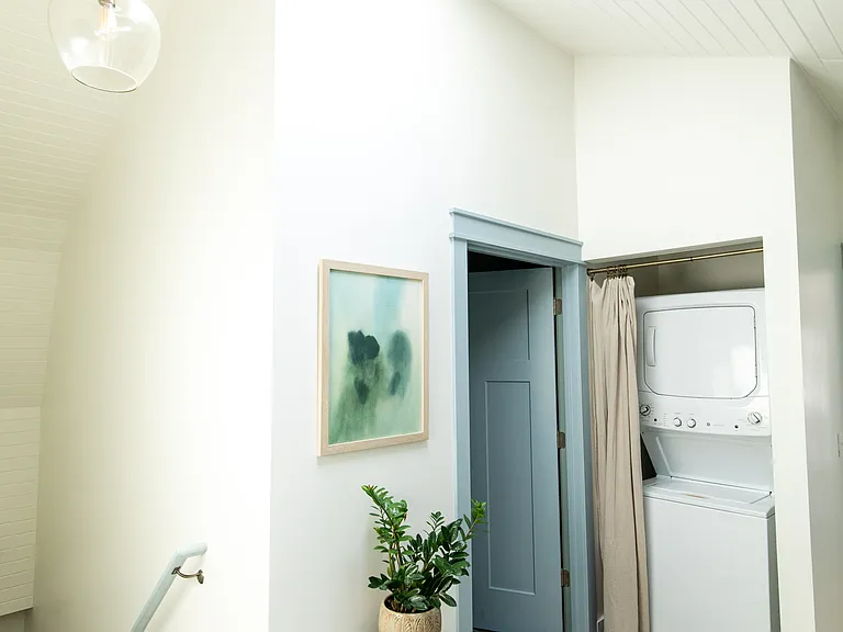 The second floor landing area has a skylight and laundry set up.