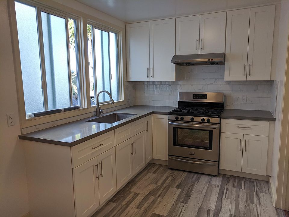 Remodeled kitchen with brand new cabinets, sink and porcelain floor tiles.