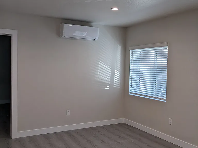 Bedroom with lots of natural light and air conditioning at The Hardison Apartments in Pasadena, California.