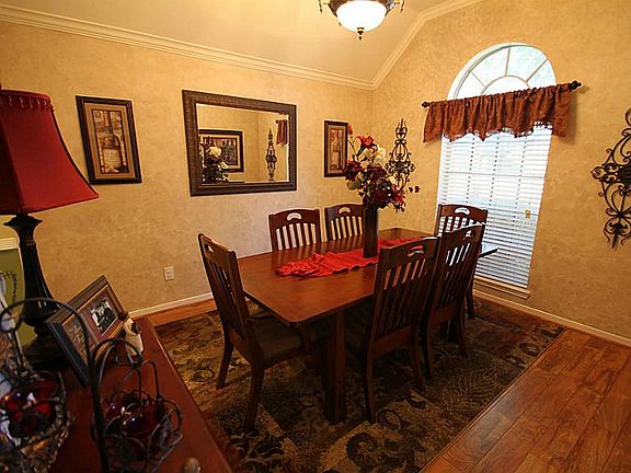 Elegant formal dining with high ceiling and wood floors.