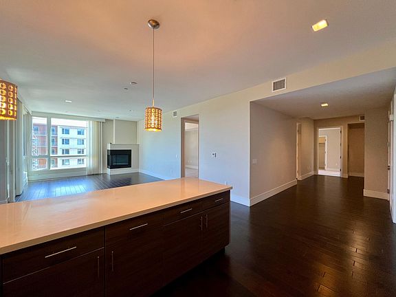 Open Kitchen, Dining & Living with Entry/Den & Hallway to Bedrooms on Right Side