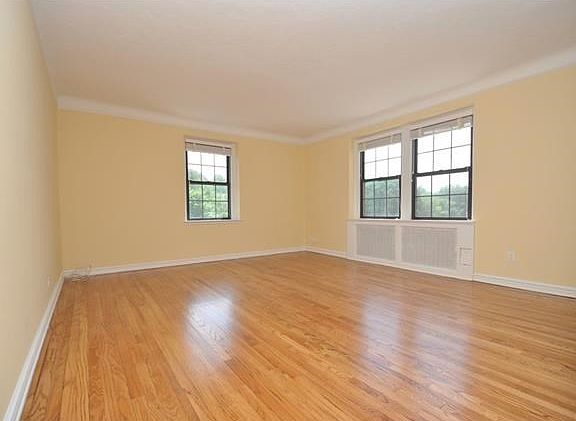 The large, sunny, corner living room has eastern and southern exposures and an arched opening to a s