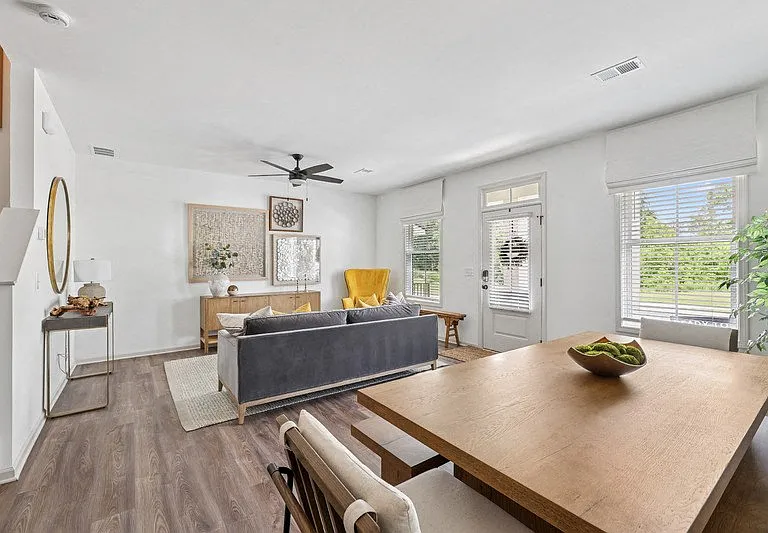 Living room with large couch, accent chairs, and windows.