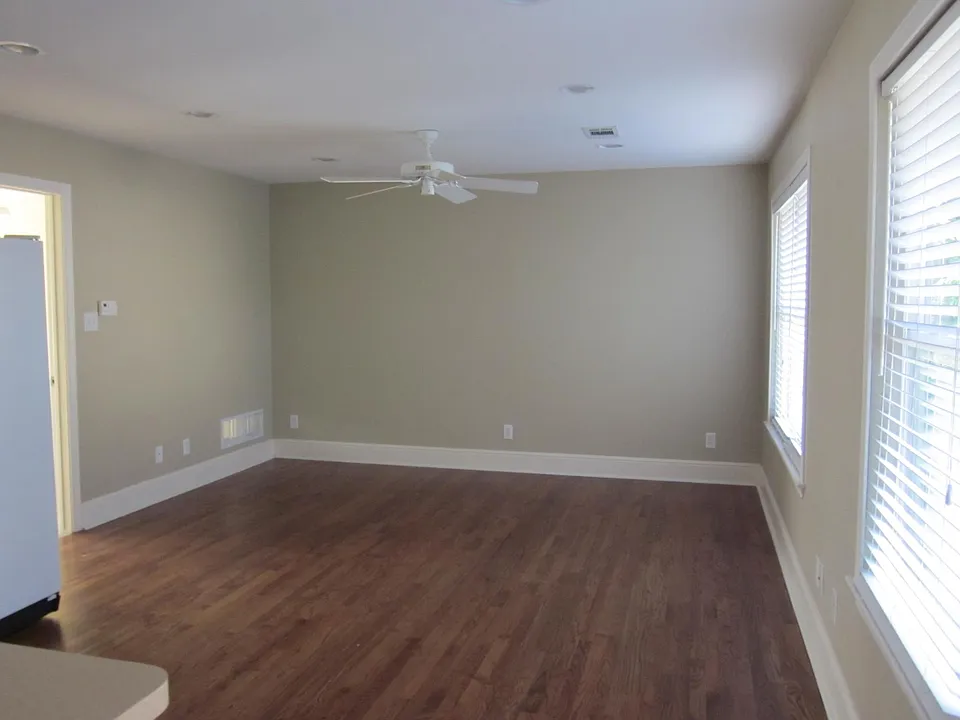 Living room looking from open kitchen. Hardwood floors.