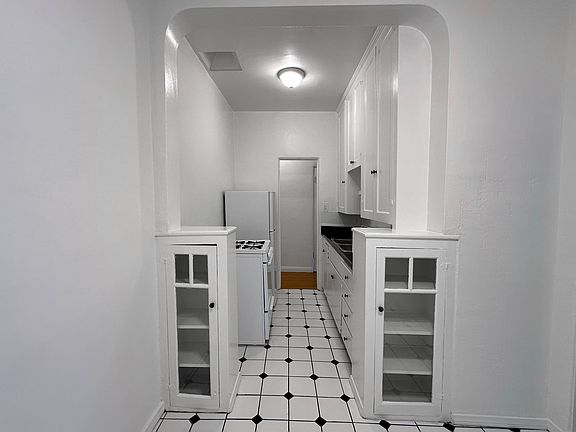 The dining area is a charming breakfast nook that connects seamlessly to the kitchen, creating an inviting space for meals. The kitchen is equipped with a gas stove and refrigerator, offering a clean and functional setup with ample storage.