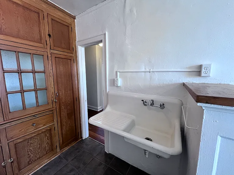 Preserved original details, including the cast iron sink, bring timeless appeal and vintage charm to this historic apartment.