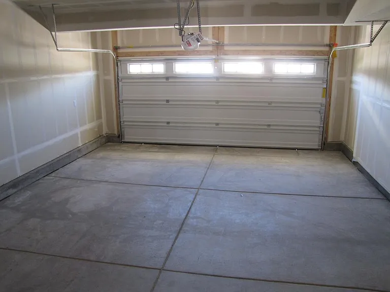 Spacious garage with hi ceiling and garage door opener