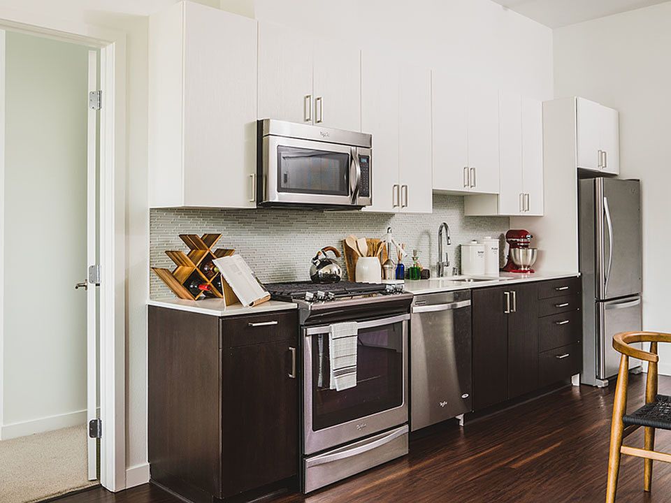 Well appointed kitchen featuring espresso lower cabinetry and white upper cabinetry