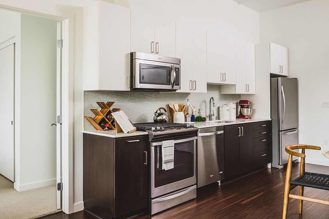 Well appointed kitchen featuring espresso lower cabinetry and white upper cabinetry