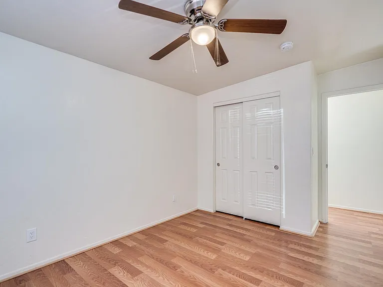 Bedroom 2 closet with ceiling fan. Entry from hallway