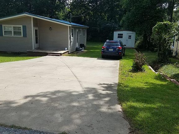 Front of house with double wide driveway.