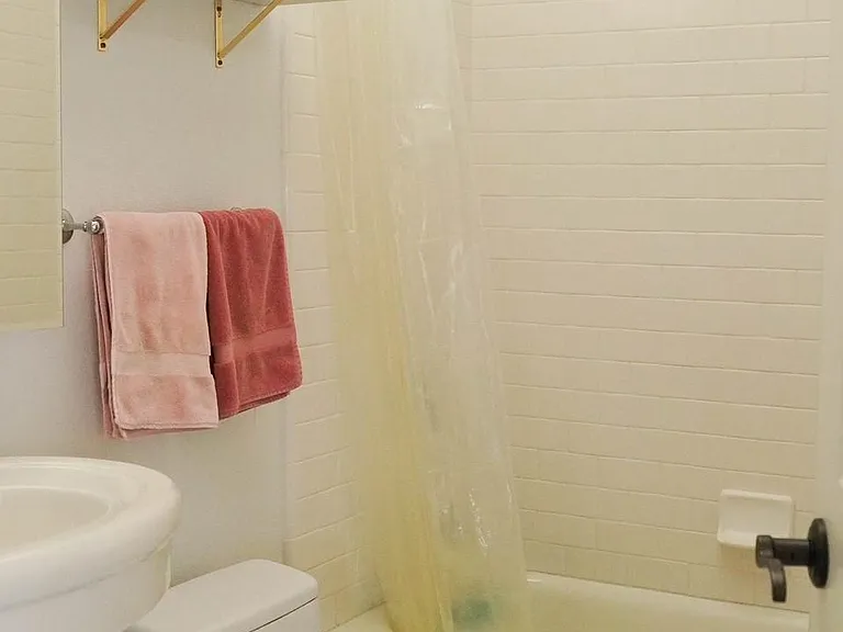 2nd bathroom, marble shelving, shower/tub combo with pedestal sink and penny-tile flooring