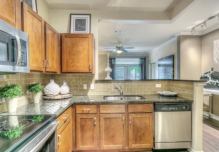 Kitchen with granite counter tops, stainless steel appliances, brown cabinetry.