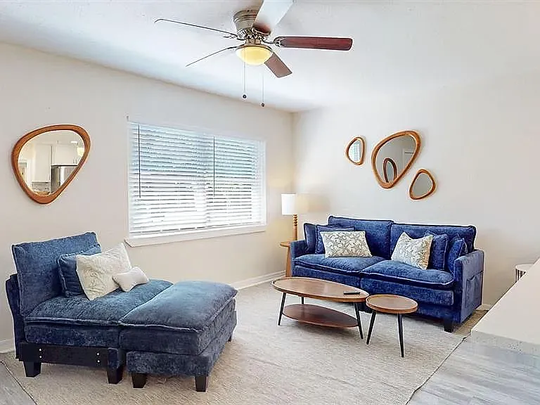 Comfortable, stylish living space with ceiling fan, natural light, and modern decor, shared by all residents